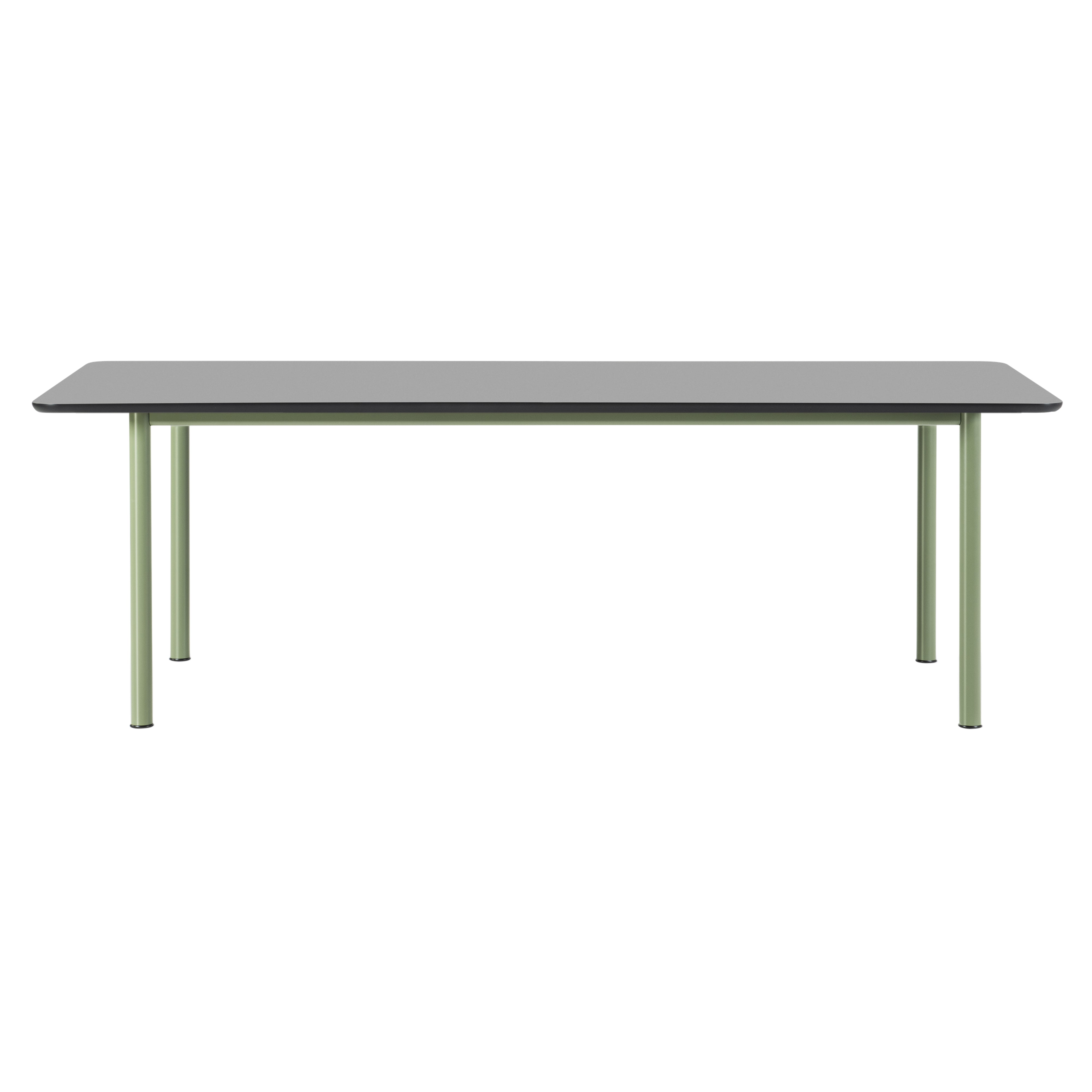 A rectangular table with a black top and slim sage green metal legs seen from the side