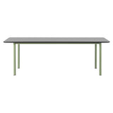 A rectangular table with a black top and slim sage green metal legs seen from the side