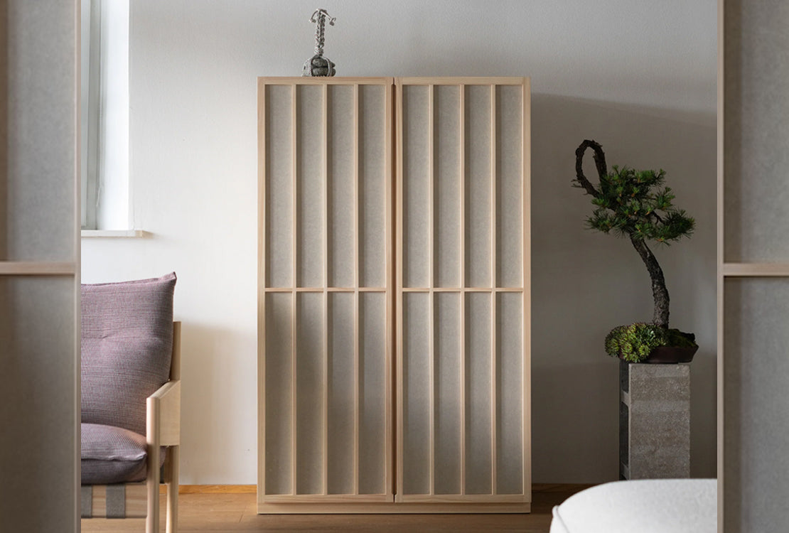 Wooden room divider in a modern interior setting with a plant and chair.