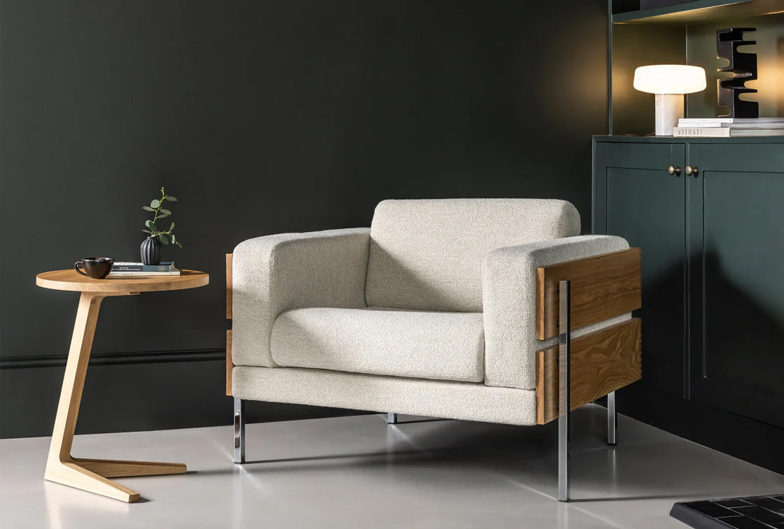 Modern armchair with wooden accents in a minimalistic room setting.