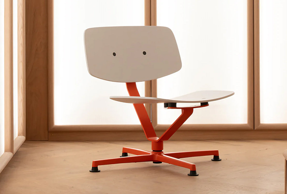 White chair with red base in a bright wooden room.