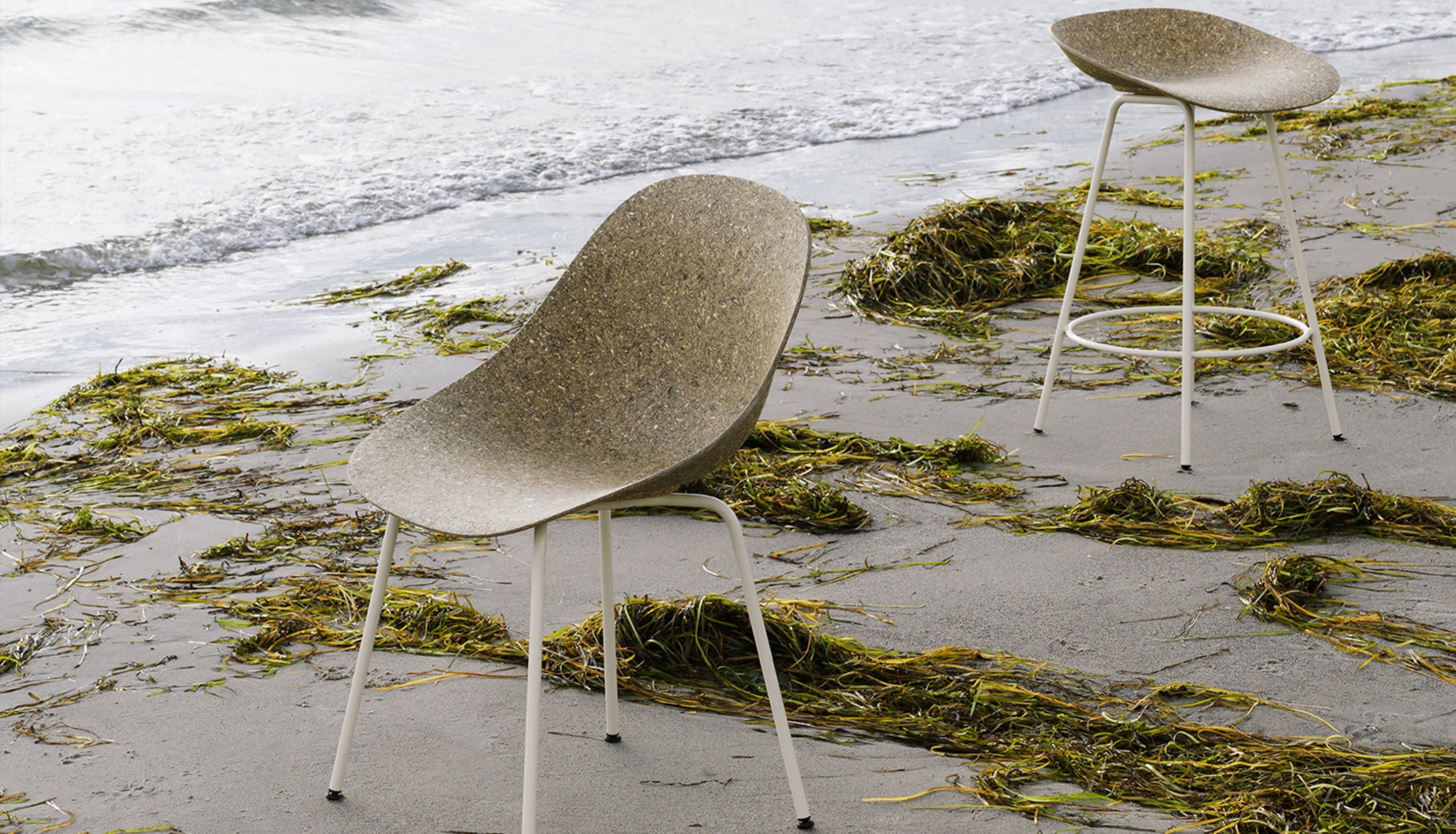 Chairs on beach surrounded by seaweed.