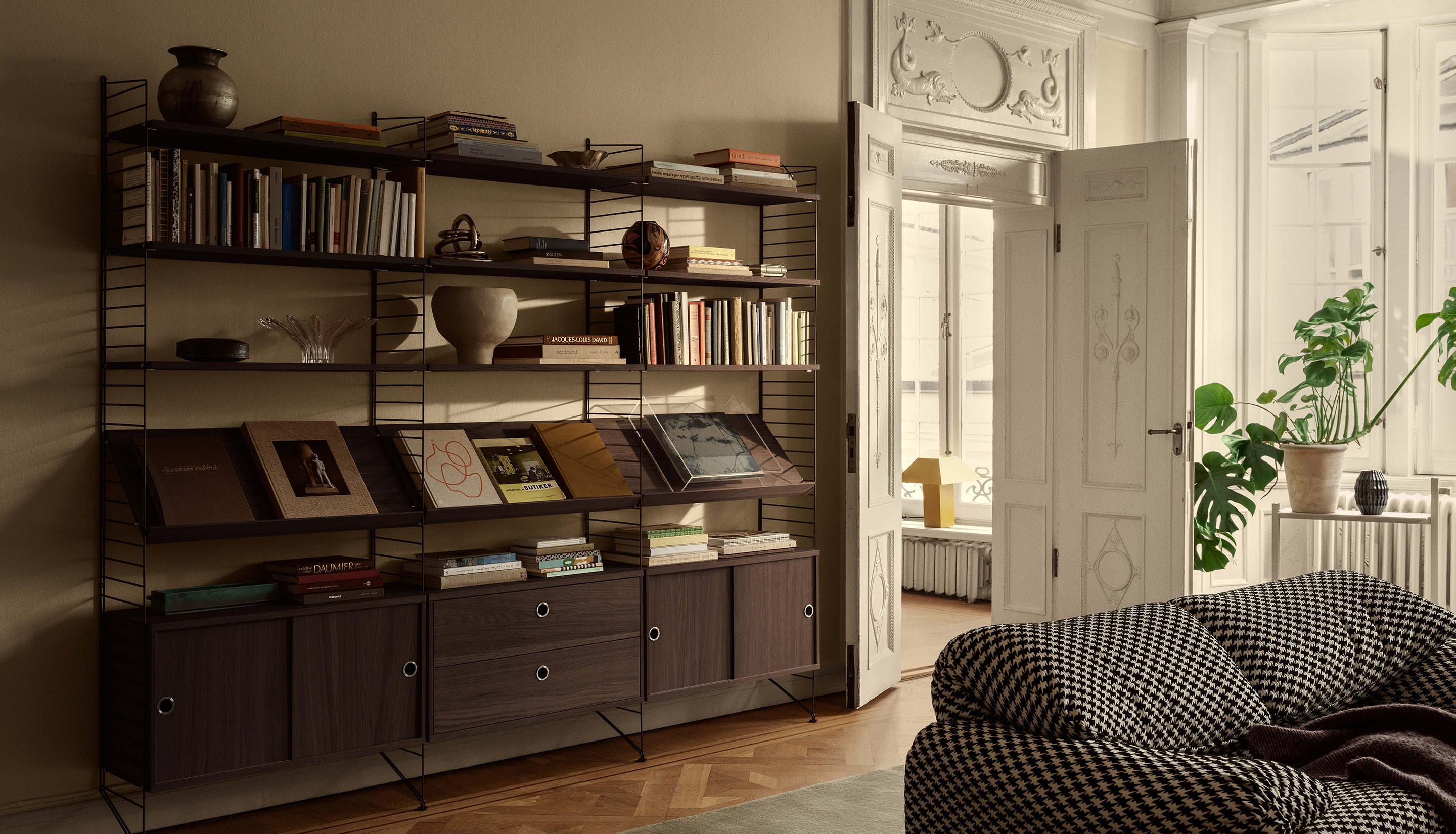 Living room with bookshelf, sofa, and open door leading to another room.