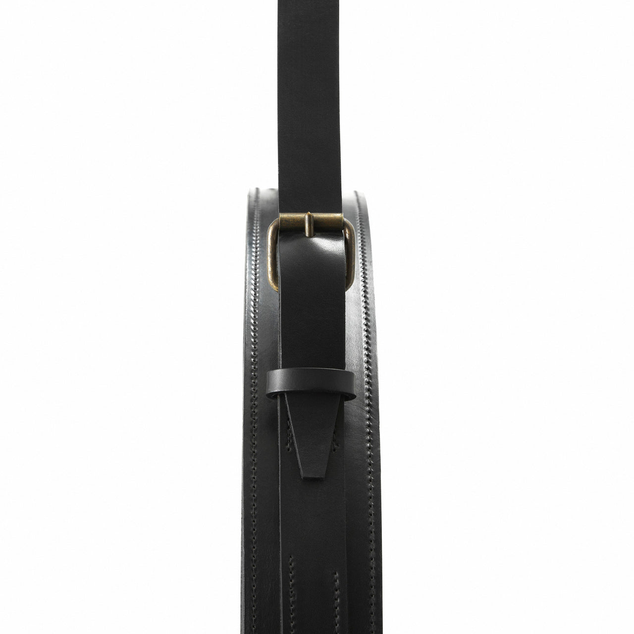 Close-up of a black stitched leather mirror edge with a strap, brass buckle and keeper loop