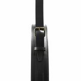 Close-up of a black stitched leather mirror edge with a strap, brass buckle and keeper loop