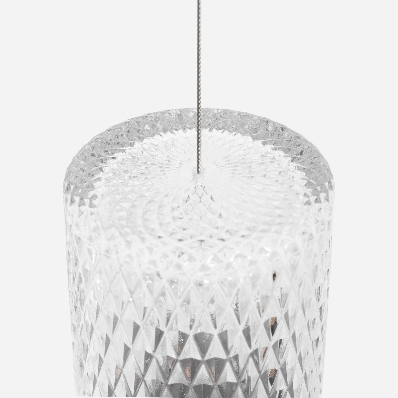 Close-up of a clear cylindrical glass pendant with a diamond-cut pattern, hung from a thin steel cable