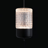 A glowing cylindrical pendant of clear diamond-patterned glass on a black base, hung from a thin cable