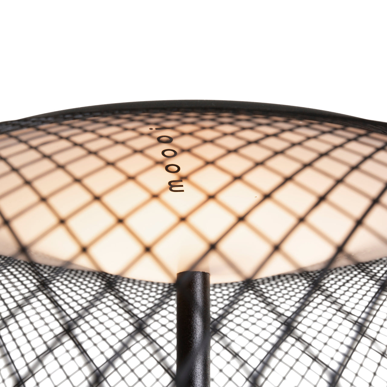 Close-up of a glowing lamp shade seen from above, covered in black diamond mesh, with a black pole beneath