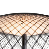 Close-up of a glowing lamp shade seen from above, covered in black diamond mesh, with a black pole beneath